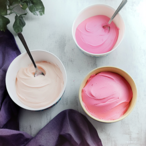 Frosting the vintage heart-shaped cake with pink buttercream 