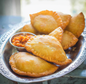 Close-up of golden-brown fried empanadas venezolanas on a plate.